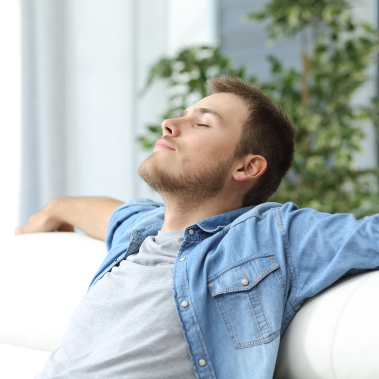 Man with closed eyes relaxing on a couch